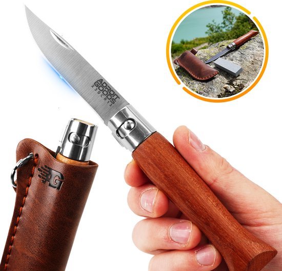 Hand houdt mes met houten handvat, leren schede met metalen clip ernaast liggend op witte achtergrond