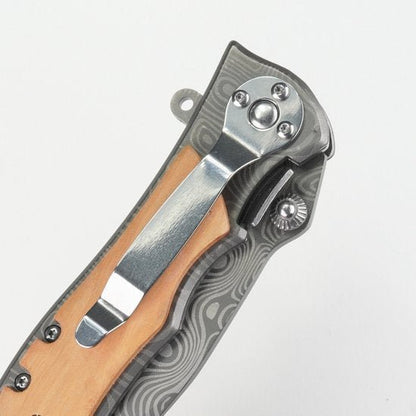 Dichtgeklapte zakmes met houten handvat en metalen clip op witte achtergrond