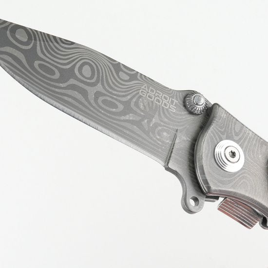 gevouwen mes met decoratief patroon en metalen handgreep in grijstinten